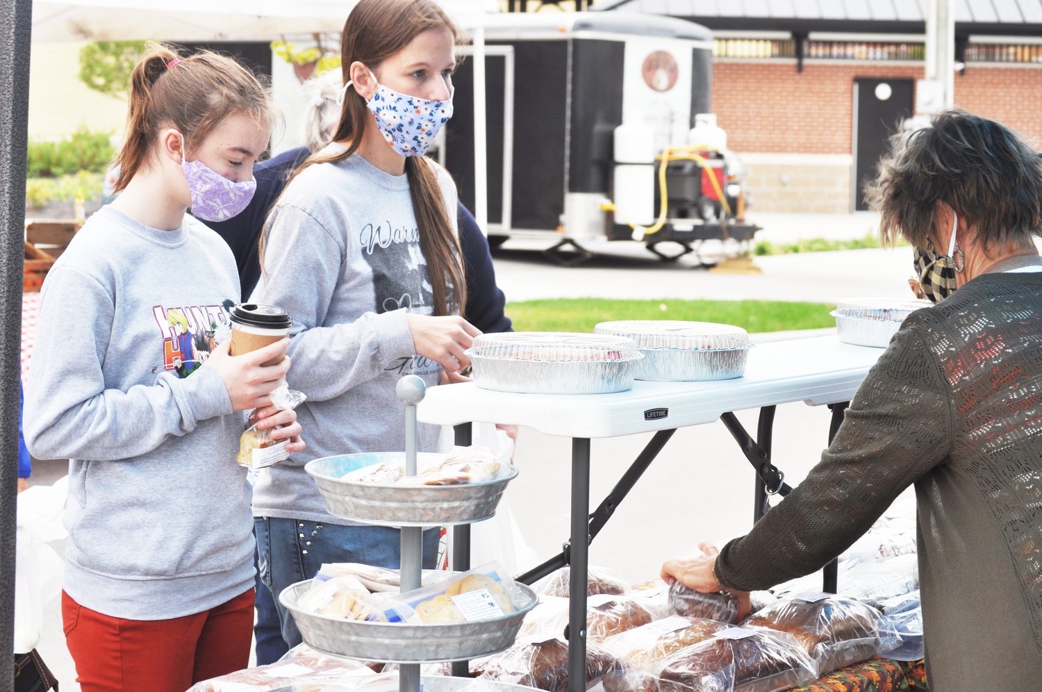 Lacey Wallace, right, and her daughter Ally Wallace purchase baked goods from Sharon Young of Thyme for All Seasons at the Crawfordsville Farmers' Market Saturday. The market was celebrating the harvest season.